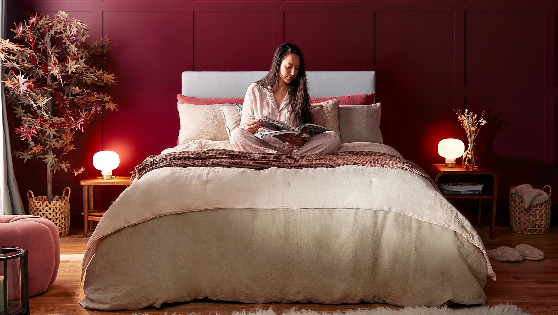 woman sat on bed reading magazine