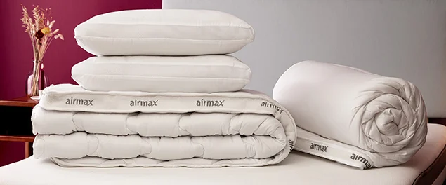 airmax pillows, duvet & mattress topper stacked on bed