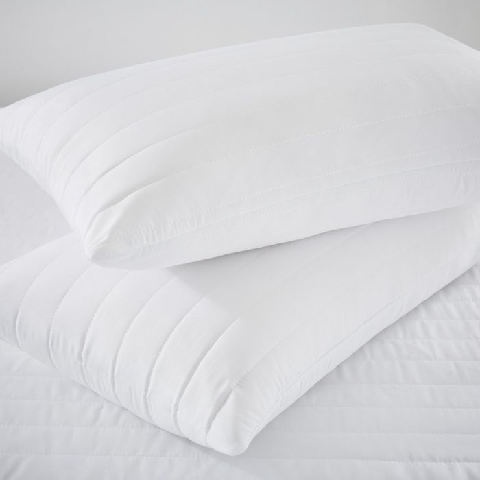 Two Silentnight Anti-Allergy Pillow Protectors stacked on top of one another on a bed