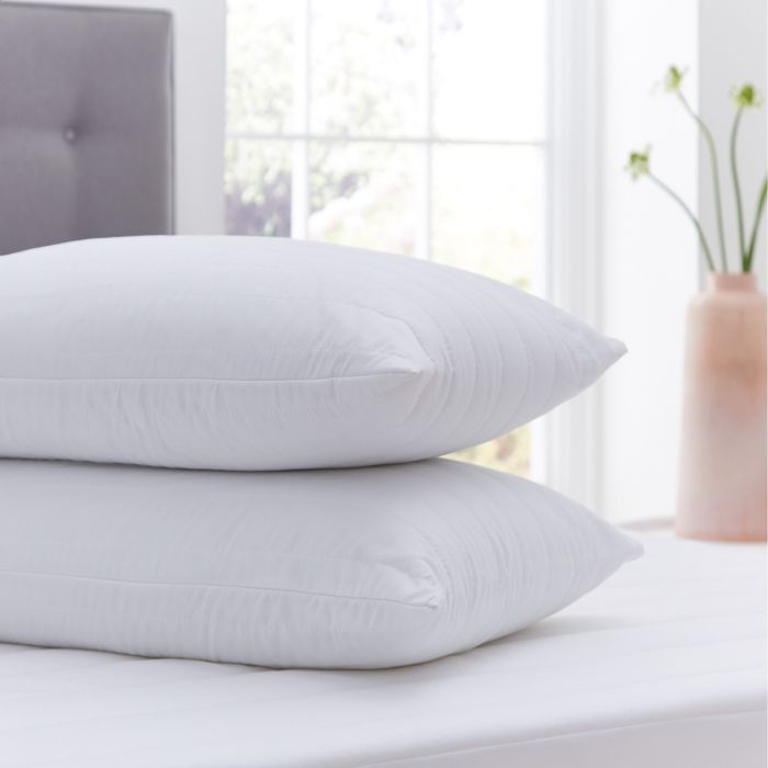 Two Silentnight Anti-Allergy Pillow Protectors stacked on top of one another on a bed 