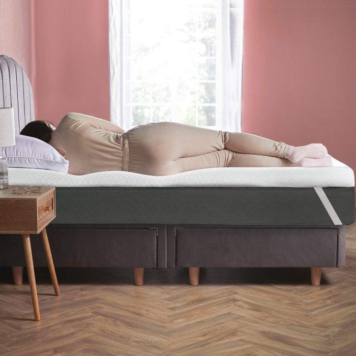 A person lay on on a Silentnight impress 5cm mattress topper in a pink room