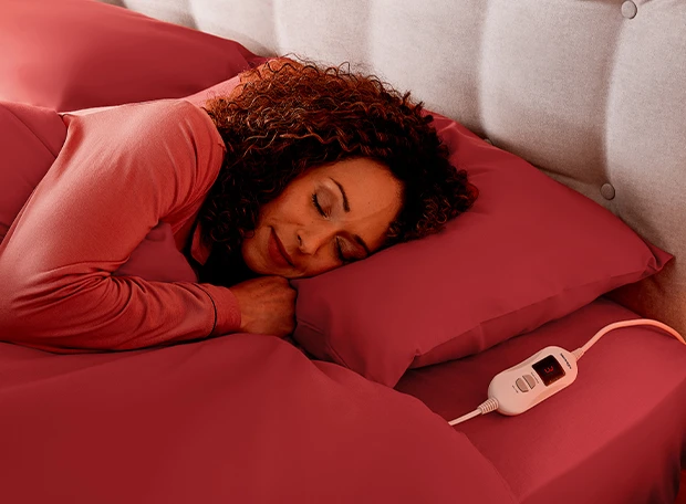 Woman sleeping with an electric blanket control switch next to her