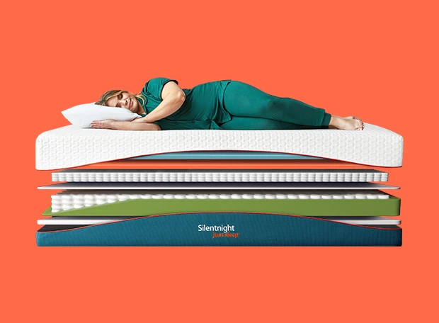 Woman laying on a just sleep mattress in green pyjamas