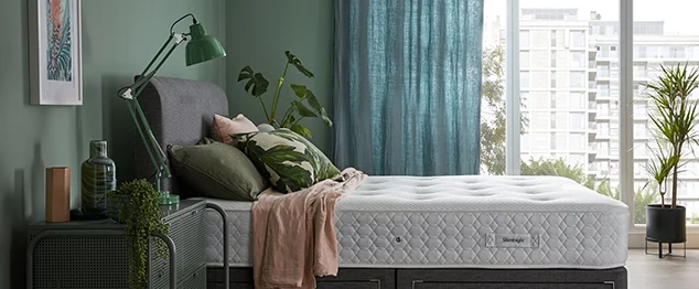 Mattress on grey divan bed in green bedroom
