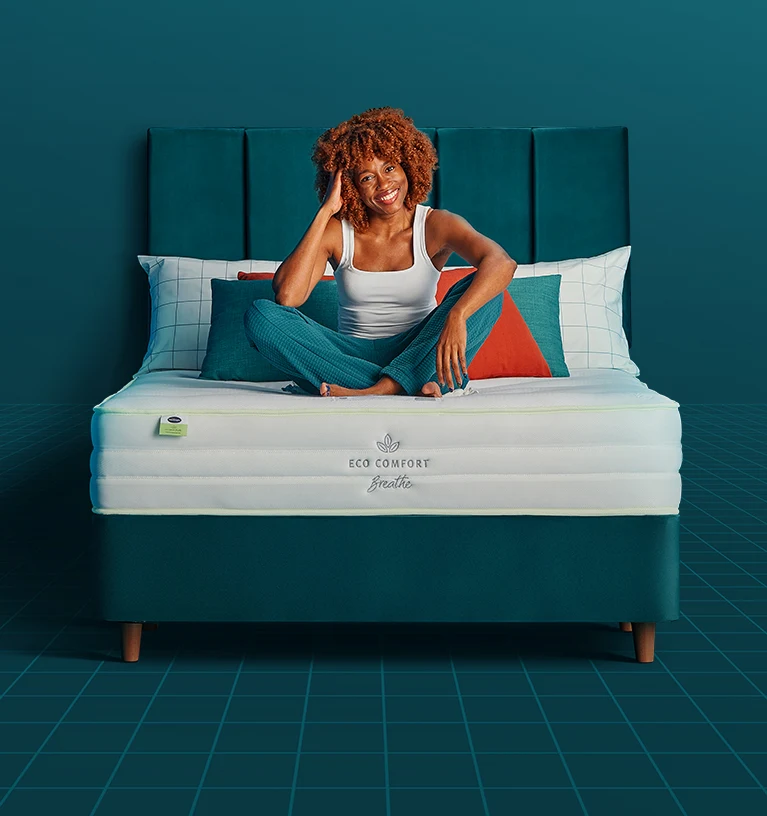 Woman sat on a bed smiling
