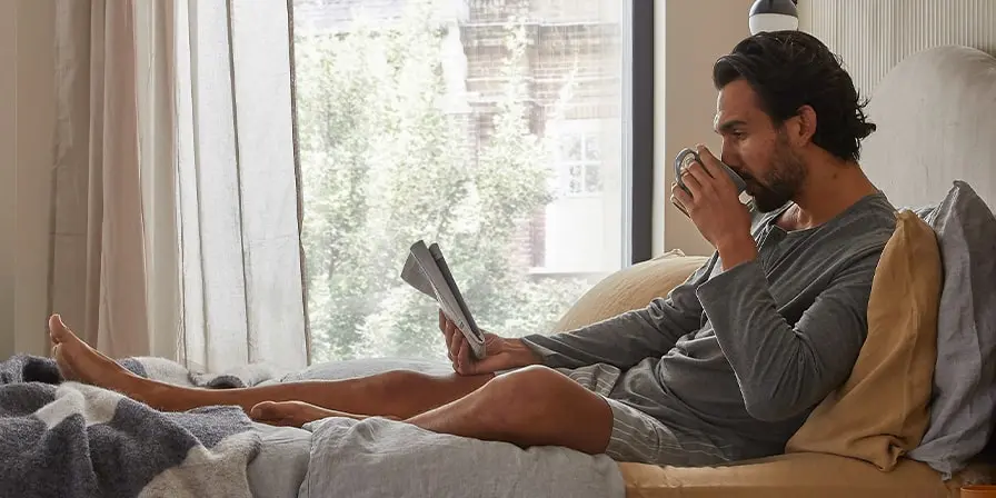 Man drinking a coffee in bed