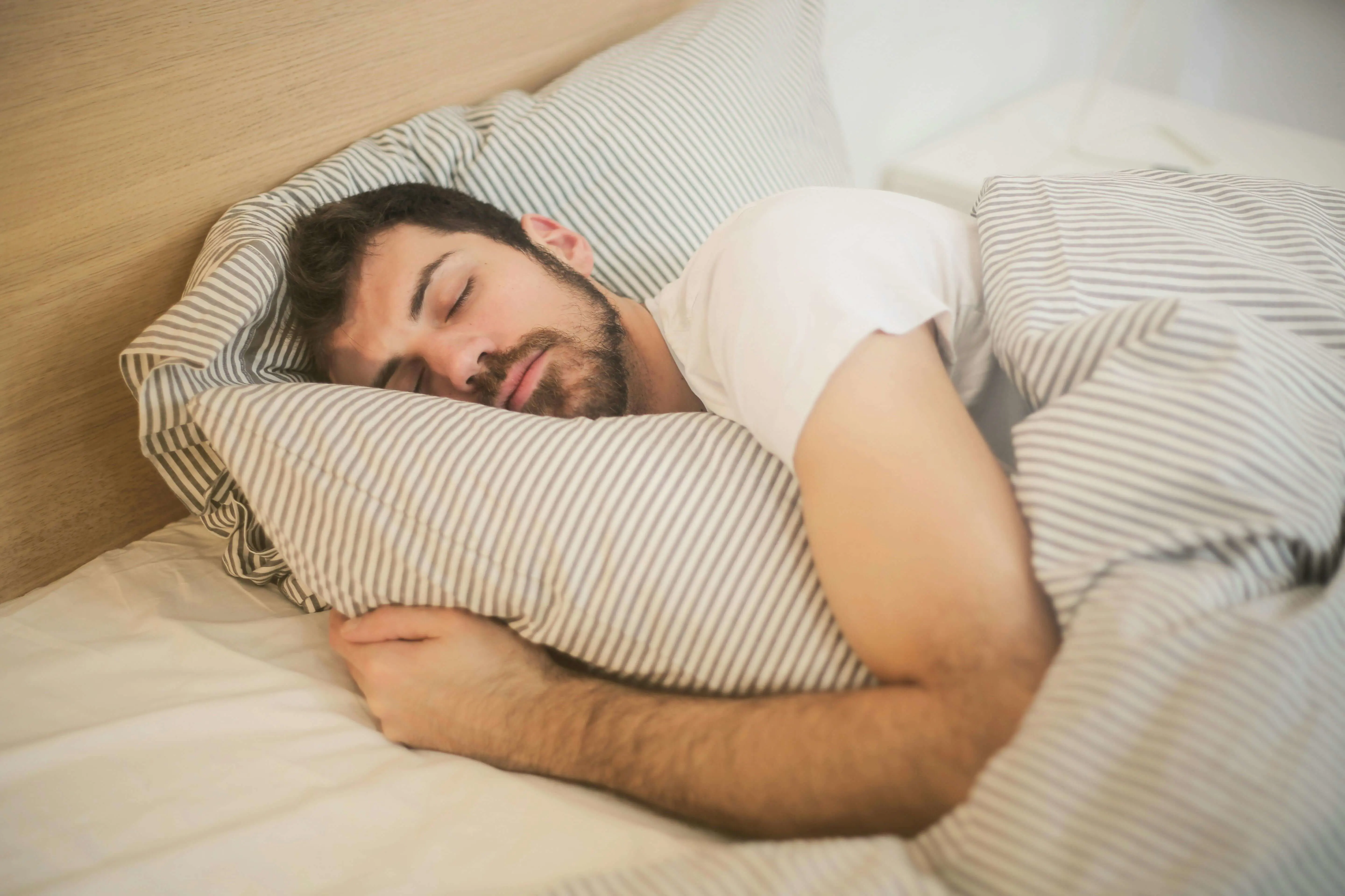 Man sleeping in a clean bed, having followed a hygienic bed practice.