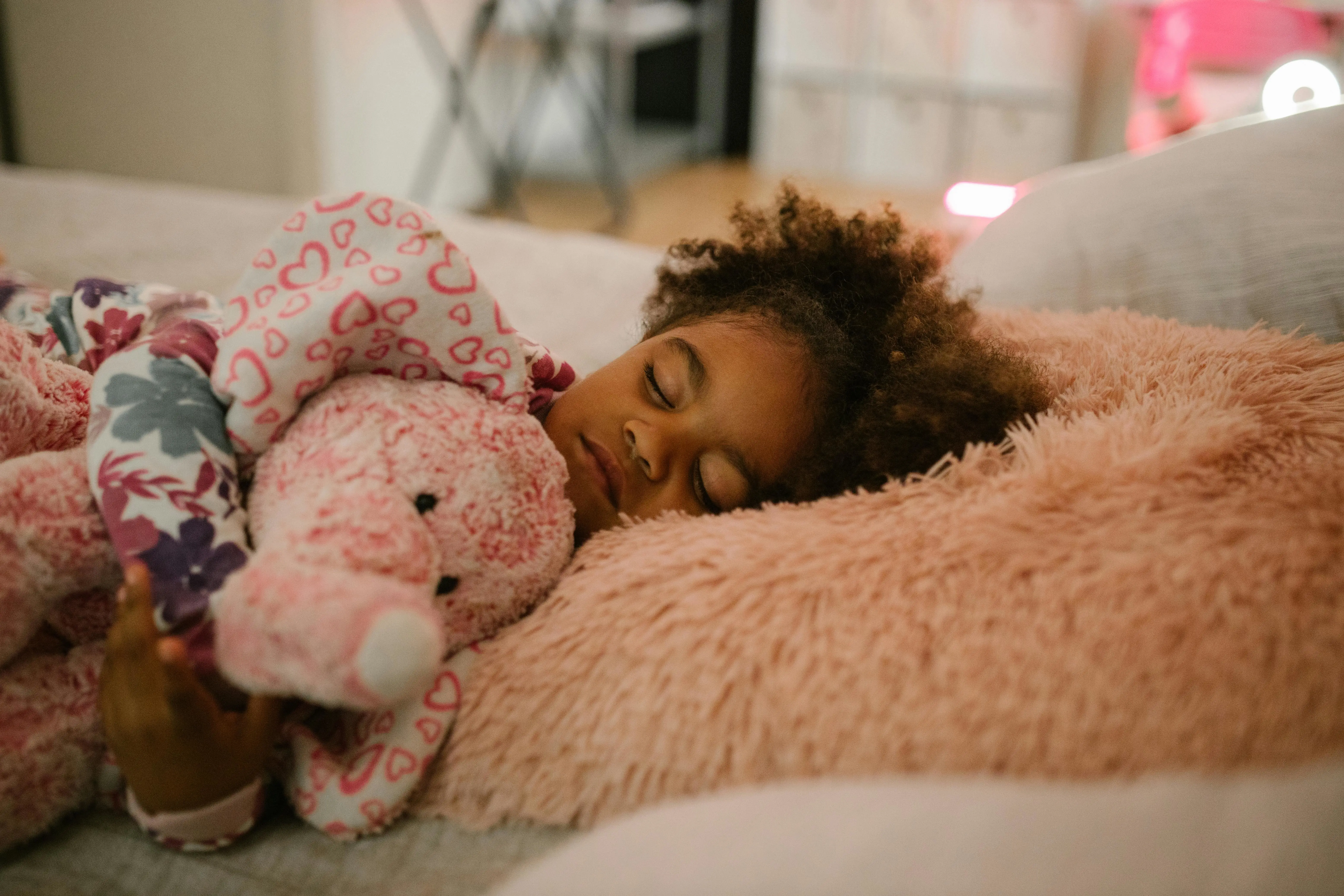 A child sleeping while cuddling a soft toy