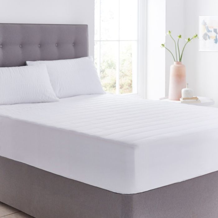 A Silentnight Anti-Allergy Mattress Protector on top of a Silentnight mattress in a white room