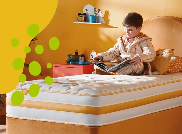 boy sat on a bed reading book