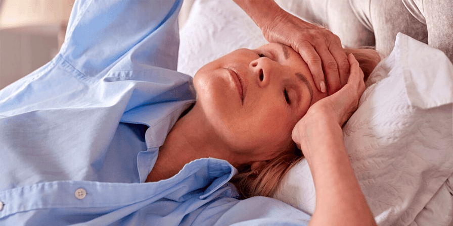 woman experiencing menopause symptoms in bed